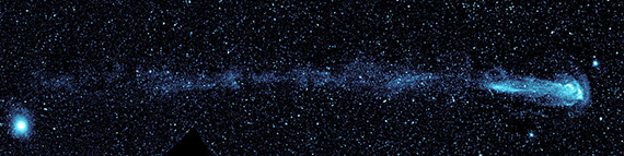 The star Omicron Ceti, also called Mira, is to the right in this image. To the right of the star is the curved bow wave, with the curve extending up and down toward the left of the image. To the left of the star and extending far to the left of the image are clumps of stellar wind material left behind as the star moves quickly through space.